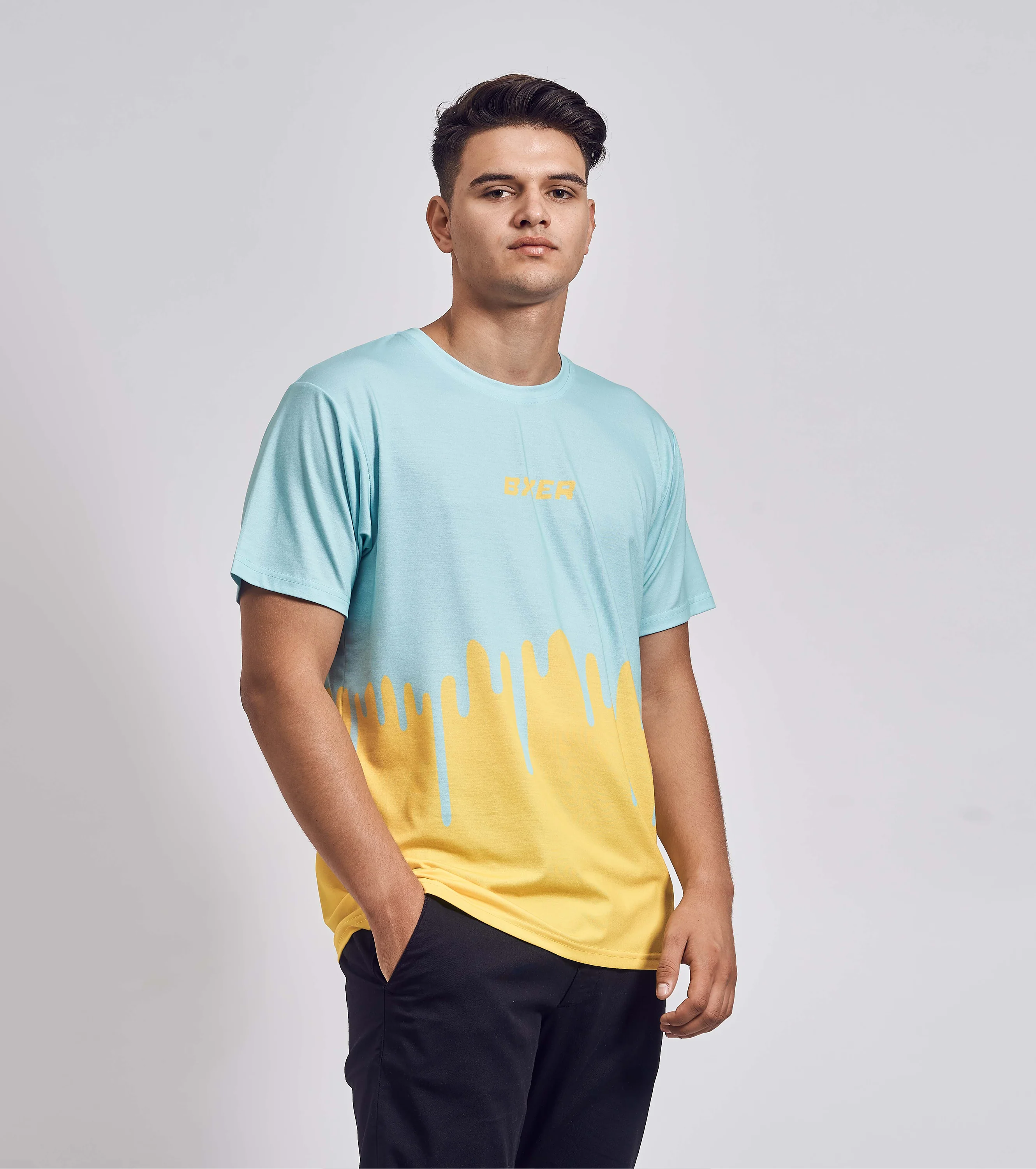 Model trägt BXER Streetwear T-Shirt in Hellblau und Gelb mit auffälligem Drip-Effekt.