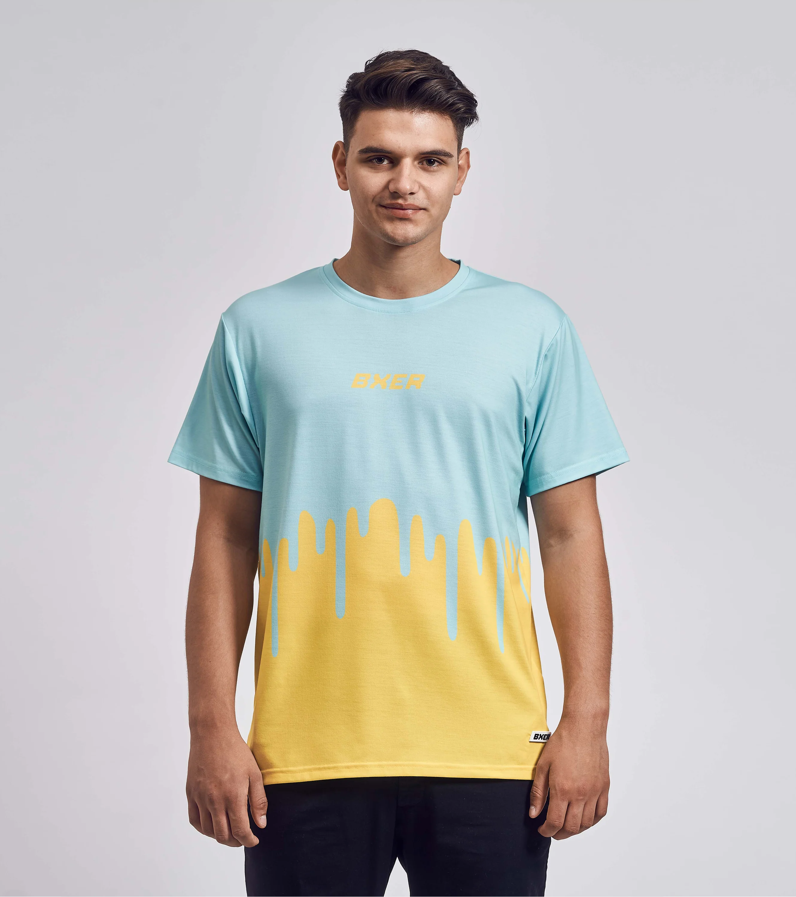 T-Shirt mit auffälligem Drip-Design in Hellblau und Gelb, frontal getragen von einem jungen Mann mit kurzen Haaren