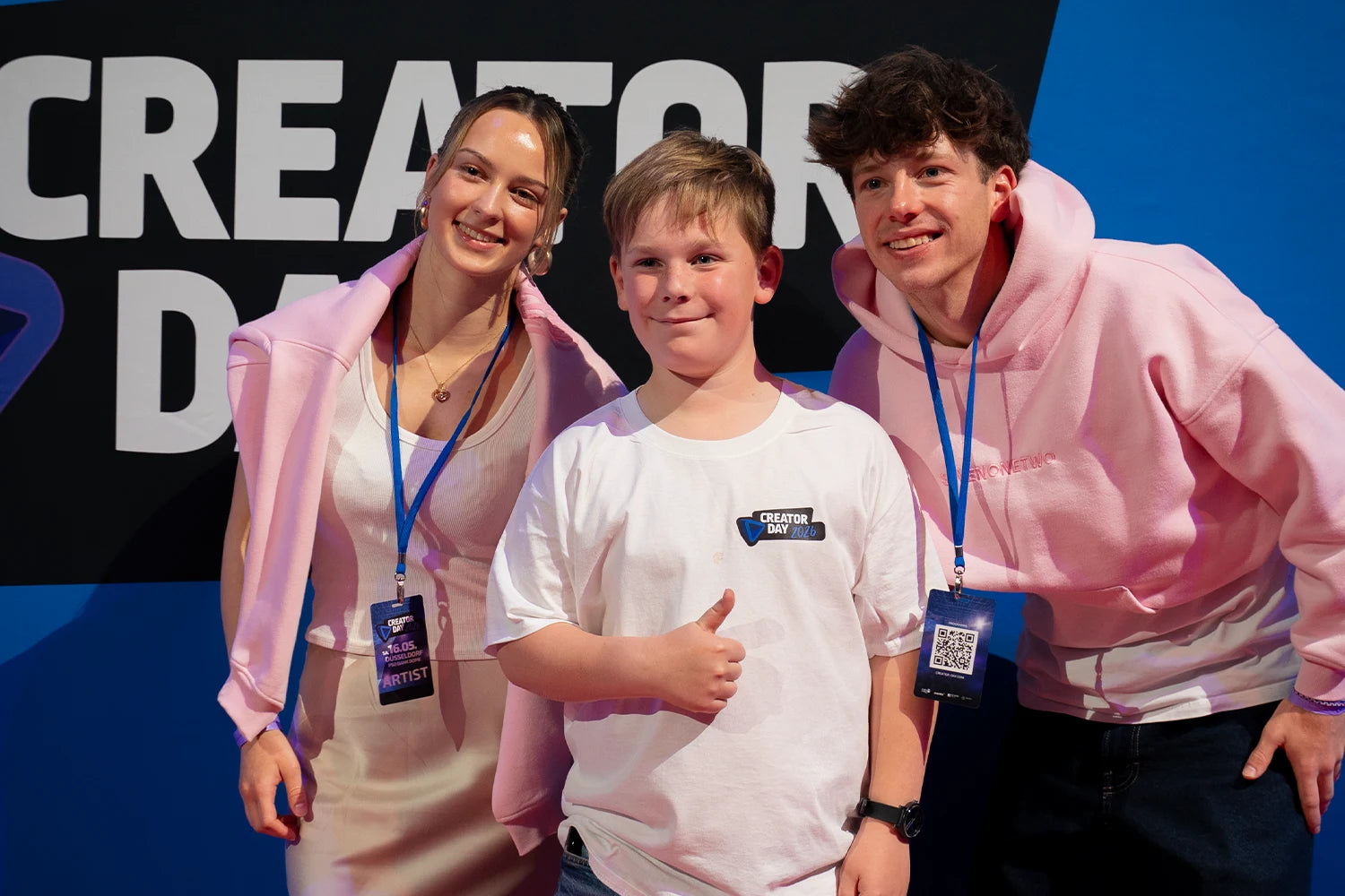 Junger Fan im weißen Creator-Day-T-Shirt steht neben seinen zwei Lieblings-Creatorn