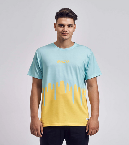 T-Shirt mit auffälligem Drip-Design in Hellblau und Gelb, frontal getragen von einem jungen Mann mit kurzen Haaren

