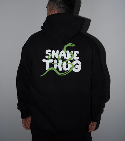 Rückansicht eines SnakeThug Hoodies mit großem weißen Print und grüner Schlange, getragen von einem männlichen Model – moderner Streetstyle mit auffälligem Rückenmotiv.







