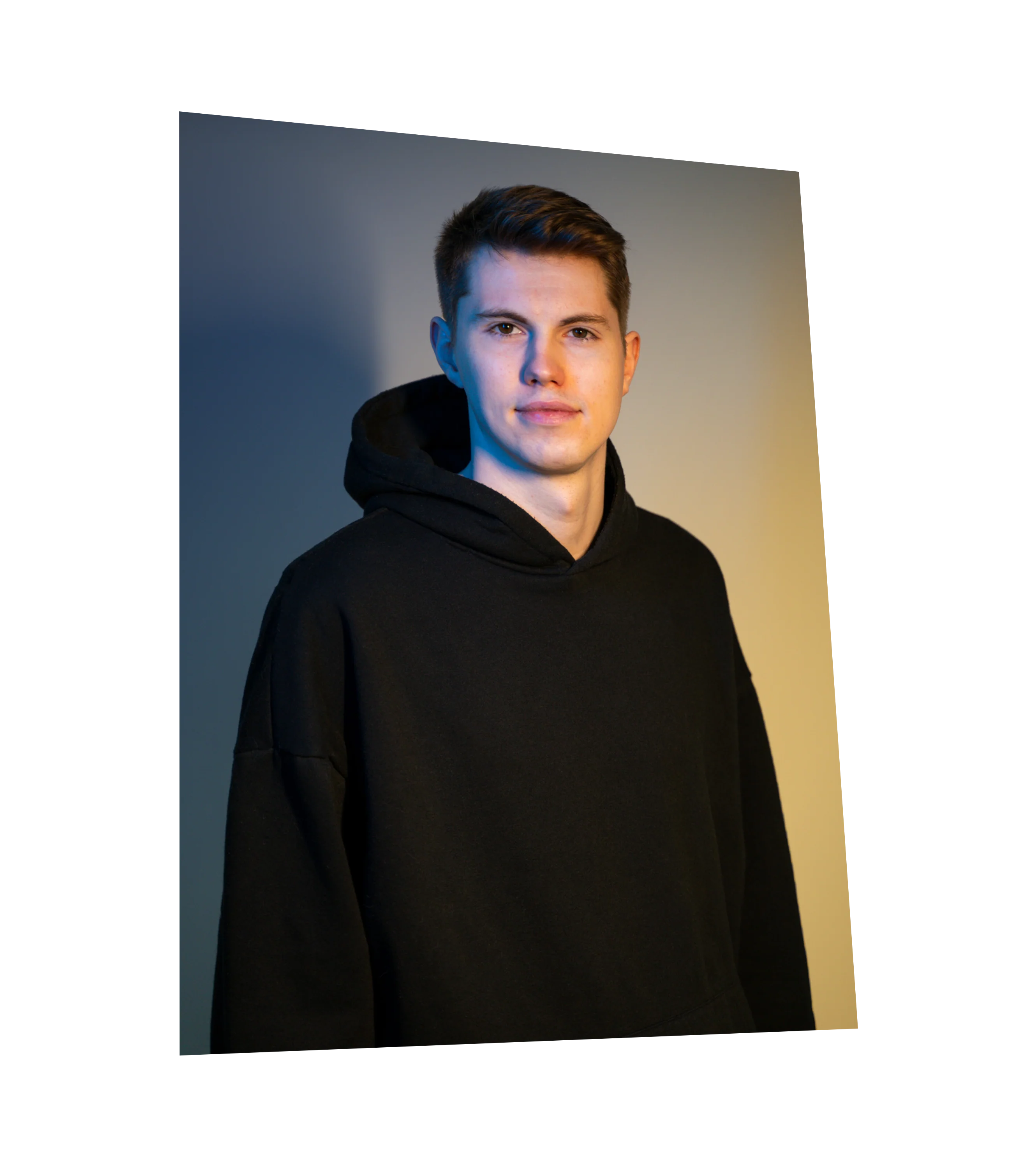 Autogrammkarte von Tim Latka mit schwarzem Hoodie vor neutralem Hintergrund, Blick in die Kamera mit leichtem Lächeln.

