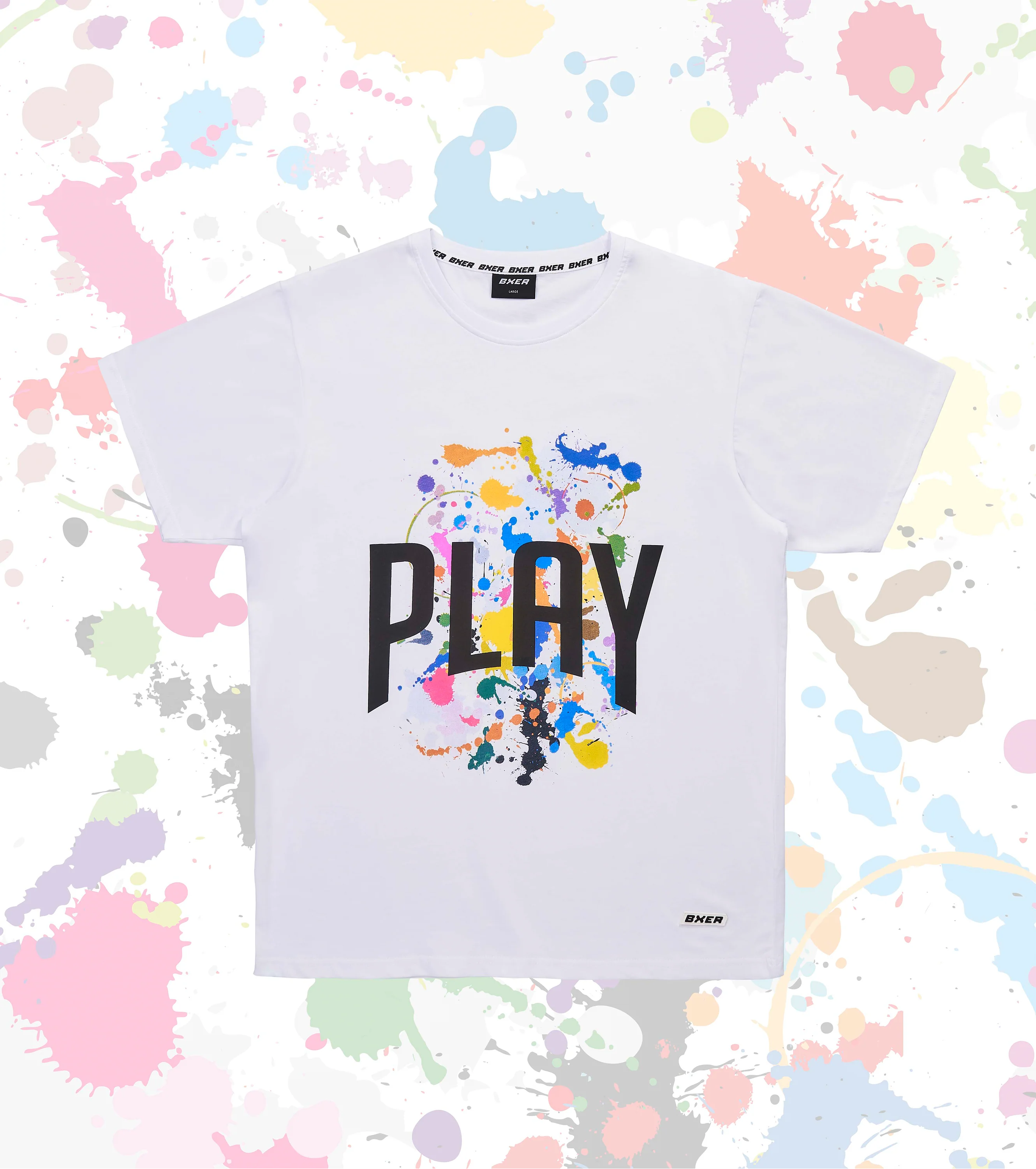 Weißes T-Shirt mit buntem Farbspritzer-Motiv und schwarzem „PLAY“-Schriftzug von BXER, flach liegend auf gesprenkeltem Hintergrund

